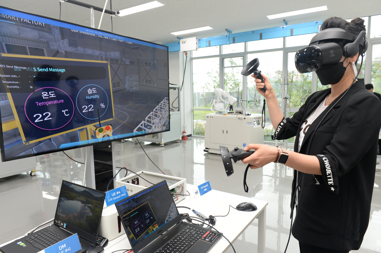 ETRI 연구진이 VR 장비를 이용해 국산 5G 기술 기반 스마트공장 내 공정 상황을 모니터링하는 모습.[ETRI 제공]