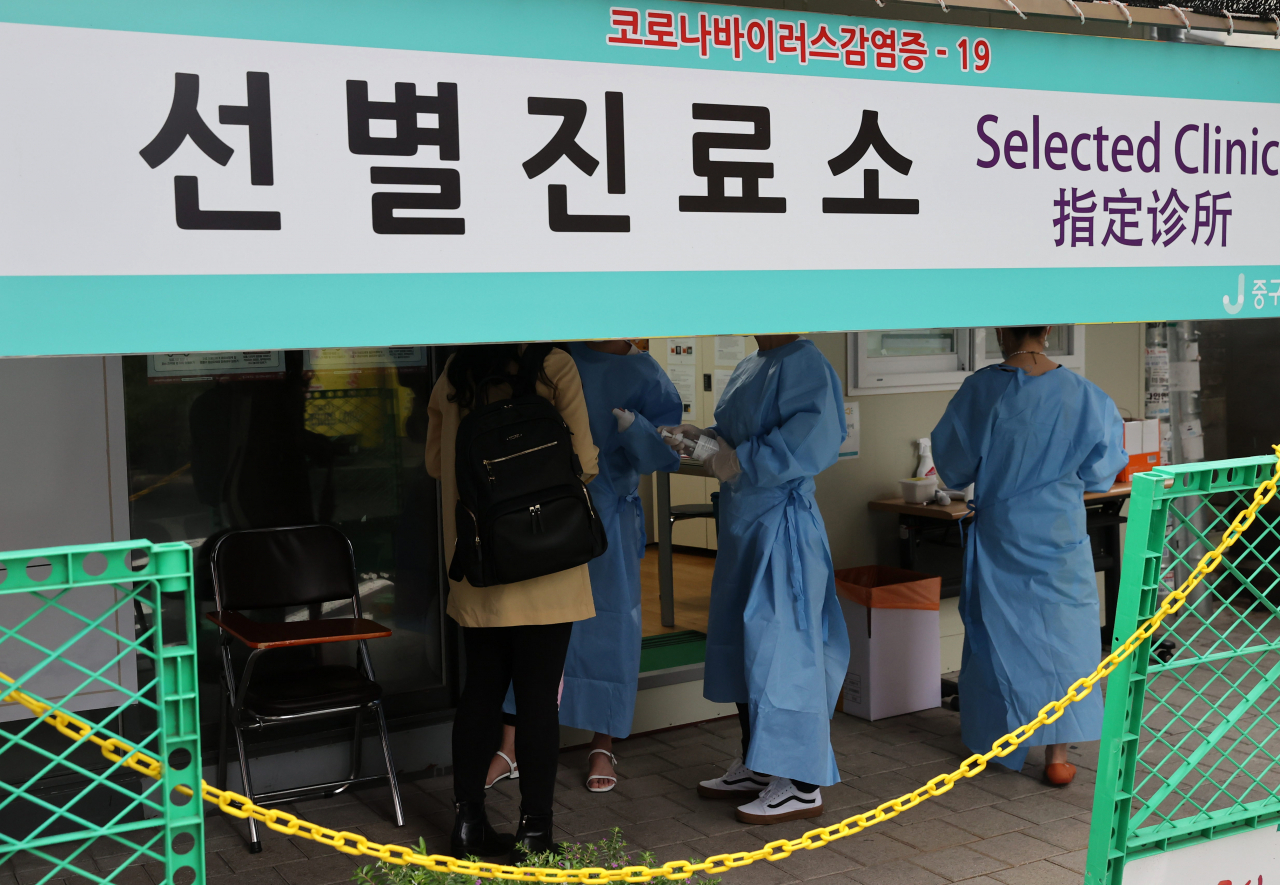 지난달 28일 오후 서울 중구 보건소 선별진료소에서 방문자가 검사에 앞서 관계자와 대화를 나누고 있다. [연합]