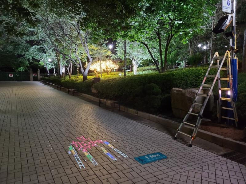 스마트 안심존 로고젝터가 도로 바닥에 로고를 투사하고 있다.