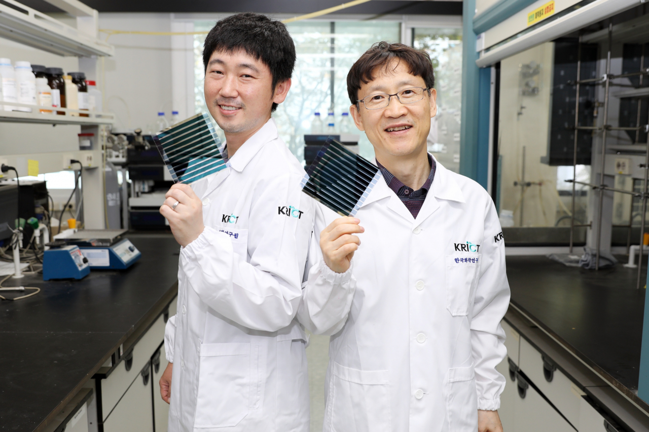 한국화학연구원 에너지소재연구센터 송창은(왼쪽) 박사와 신원석 박사가 새로 개발한 광활성 신소재가 적용된 유기태양전지를 들고 있다. [한국화학연구원 제공]