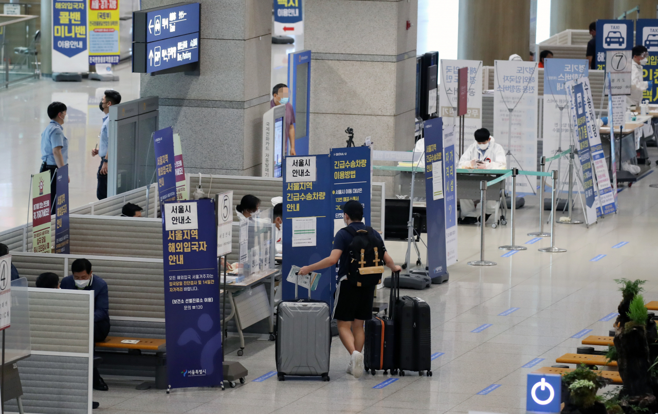 29일 영종도 인천국제공항 제1터미널 입국장에서 해외입국자들이 코로나19 바이러스 관련 안내를 받고 있다. [연합]