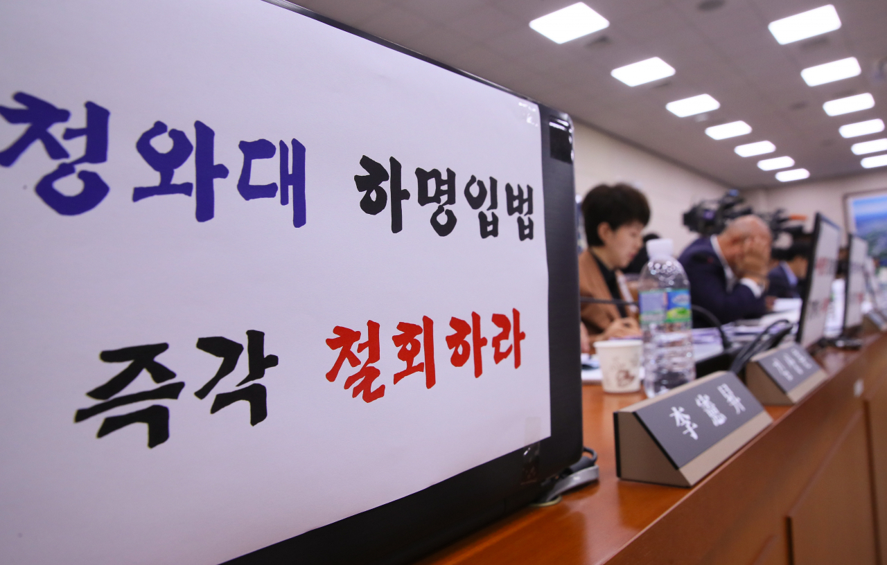 미래통합당 의원들이 29일 국회 국토교통위원회 전체회의에서 노트북에 '청와대 하명입법 즉각 철회하라' 문구를 붙이고 참석하고 있다. [연합]