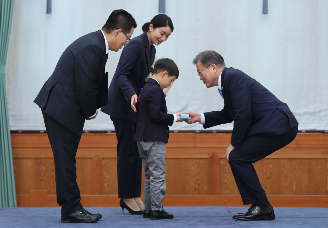 문재인 대통령이 29일 청와대에서 박지원 신임 국가정보원장에게 임명장을 수여한 뒤 박 원장의 손자에게 기념품을 주고 있다. [연합]