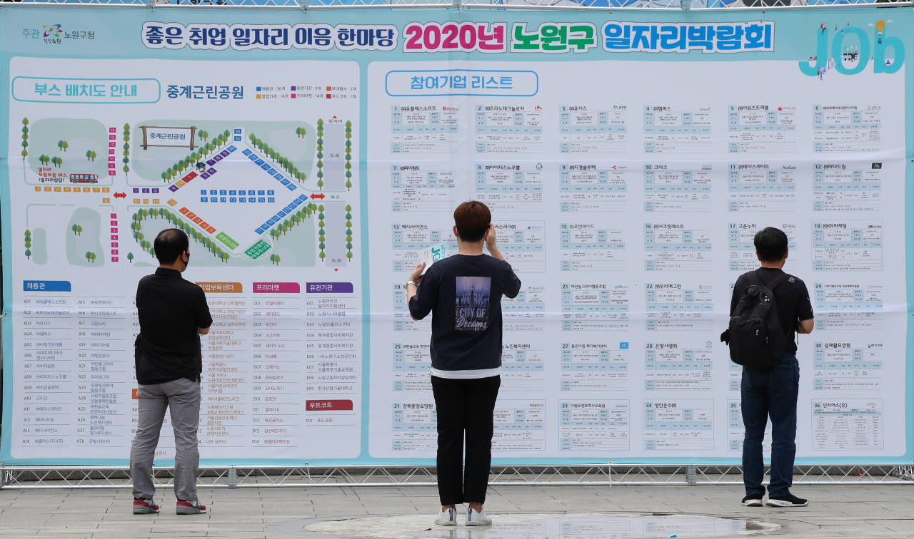 지난 15일 오전 서울 노원구 중계근린공원에서 열린 2020 노원구 일자리박람회에서 시민들이 참여업체 리스트를 확인하고 있다. [연합]