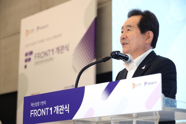 Prime Minister Chung Se-kyun holds a canned coffee made by an autonomous articulating arm -- robot -- in an exhibition booth at the opening event of Front 1, a startup incubator launched by South Korean startup accelerator D.Camp in Mapo-gu, northwestern Seoul, on Thursday. (Yonhap)