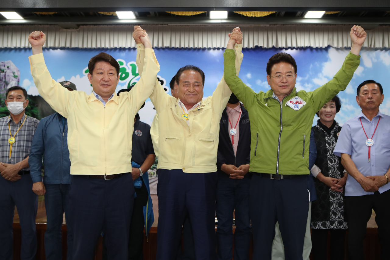 30일 오후 경북 군위군청에서 권영진 대구시장(왼쪽부터), 김영만 군위군수, 이철우 경북지사가 대구통합 신공항 이전지를 공동후보지로 신청할 것을 조건부 합의 후 손을 맞잡고 있다. 국방부 대구 군 공항 이전부지 선정위원회는 지난 3일 단독후보지(군위군 우보면)에 대해 부적합 결정을 내리고 공동후보지(군위군 소보면·의성군 비안면)는 오는 31일까지 적합 여부 판단을 유예한 상태다. 군위군은 그동안 단독후보지를 고수하다 이날 막판 협상 끝 조건부로 공동후보지에 합의했다. [연합]