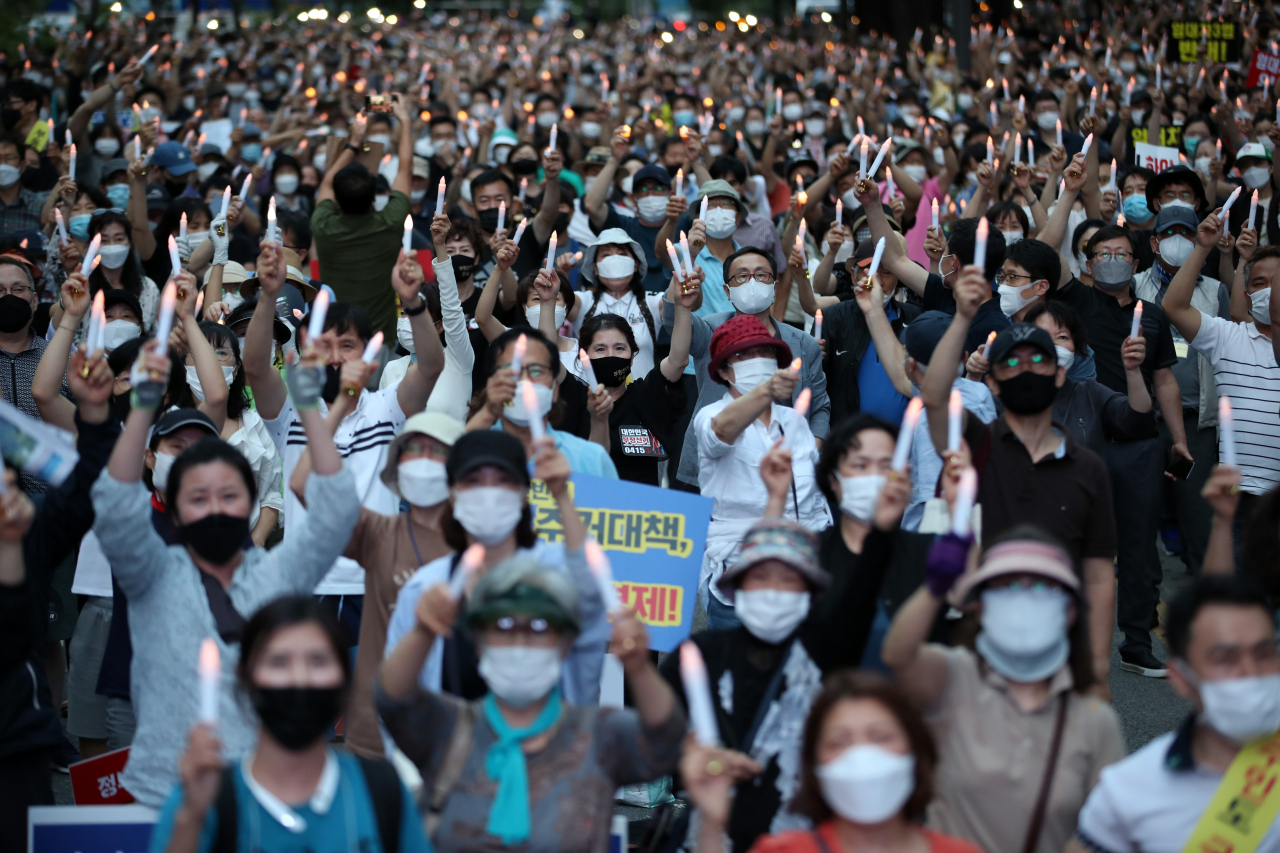 지난달 25일 오후 서울 중구 예금보험공사 앞에서 열린 ‘소급적용 남발하는 부동산 규제 정책 반대, 전국민 조세 저항운동 촛불집회’ 참가자들이 촛불을 들고 있다. [연합]