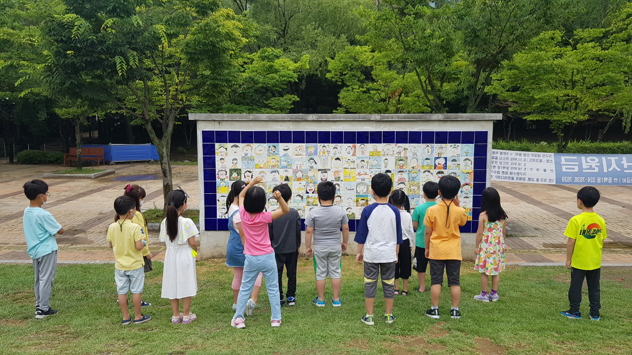 새물근린공원 타일벽화를 보고 있는 동백초 어린이들. [용인시 제공]