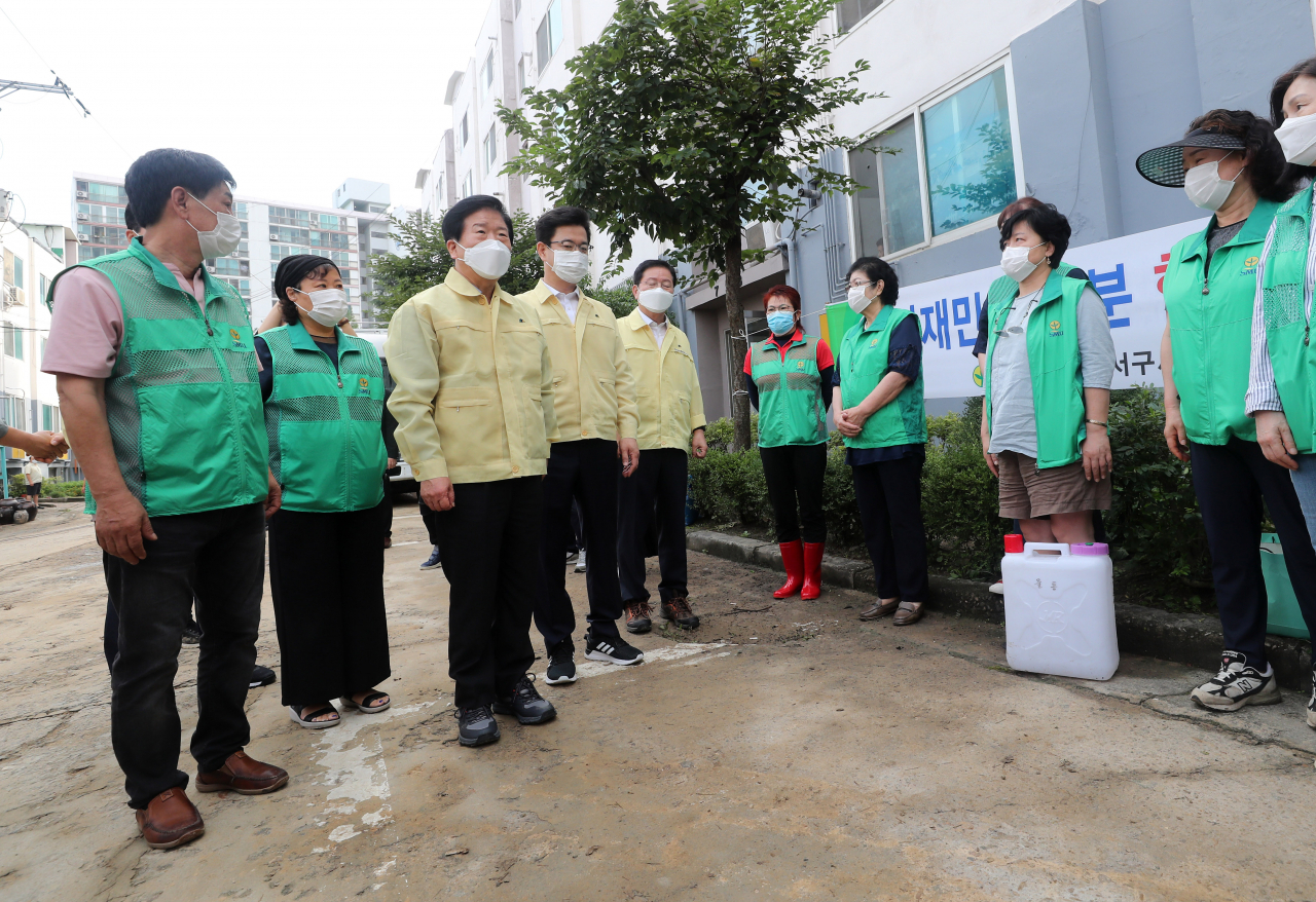 박병석 국회의장(왼쪽 세번째)이 31일 오전 침수 피해를 본 대전시 서구 정림동 코스모스아파트를 찾아 봉사단체 회원을 격려하고 있다. 연합뉴스