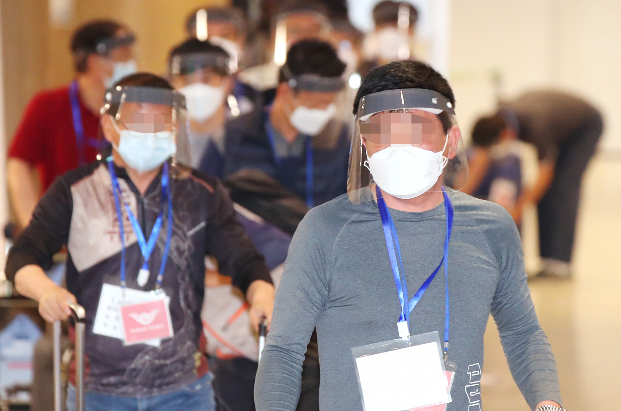 지난 31일 오전 인천국제공항을 통해 귀국한 이라크 건설 현장 파견 근로자들이 입국장에 들어서고 있다. 탑승 전 미리 실시한 코로나19 진단검사에서 양성 판정을 받은 근로자들은 의료기관 또는 생활 치료센터에 이송돼 치료를 받게 되며 음성 판정을 받은 경우 임시 생활시설에서 2주 동안 격리된다. [연합]