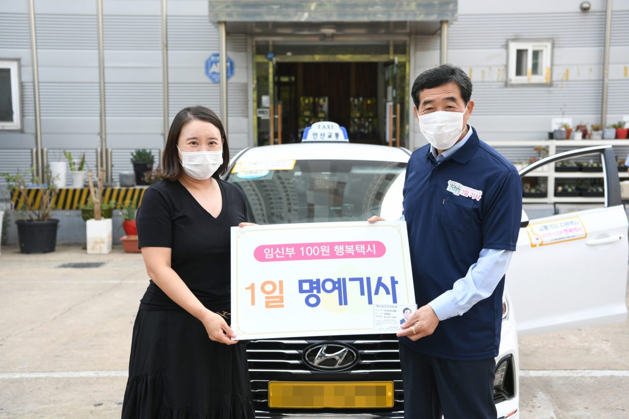 윤화섭 안산시장이 지난달 16일 ‘임신부 100원 행복택시’ 일일 기사로 나서 시민과 택시 앞에서 기념촬영을 하고 있다. [안산시 제공]