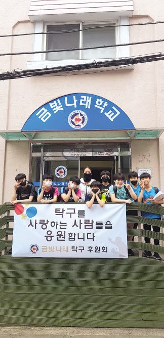 체육전문대안학교 금빛나래학교의 정문에서 학생선수들이 포즈를 취하고 있다.