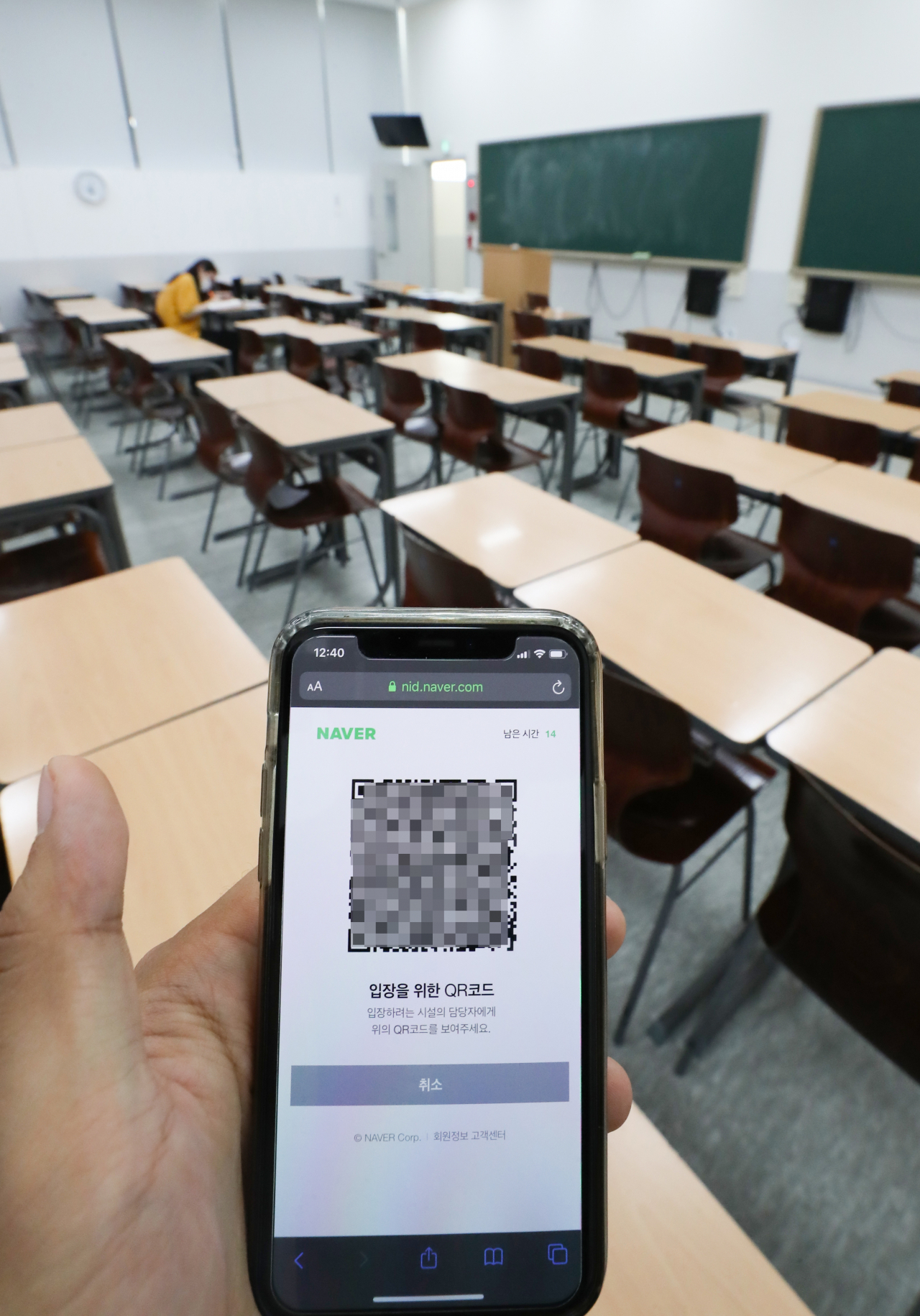 서울 마포구 종로학원 강북 본원에서 학원 관계자가 입장 QR코드가 담긴 휴대전화를 들어보이고 있다. [연합]