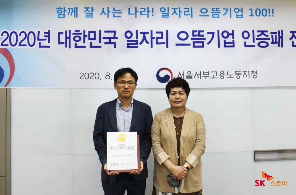 신양균 SK스토아 경영지원그룹장(사진 왼쪽), 김영미 서울서부고용노동지청장이 '2020년 대한민국 일자리 으뜸기업 인증패 전달식'에서 기념사진을 찍고 있다. [SK스토아 제공]