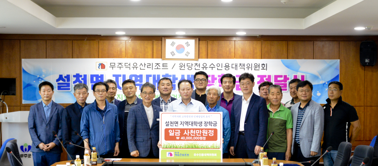 부영그룹 무주덕유산리조트 임직원들이 지난달 31일 오후 원당천유수인용대책위원회 이강전 위원장에게 저소득가구 대학생 장학금을 전달하고 있다. [부영그룹 제공]