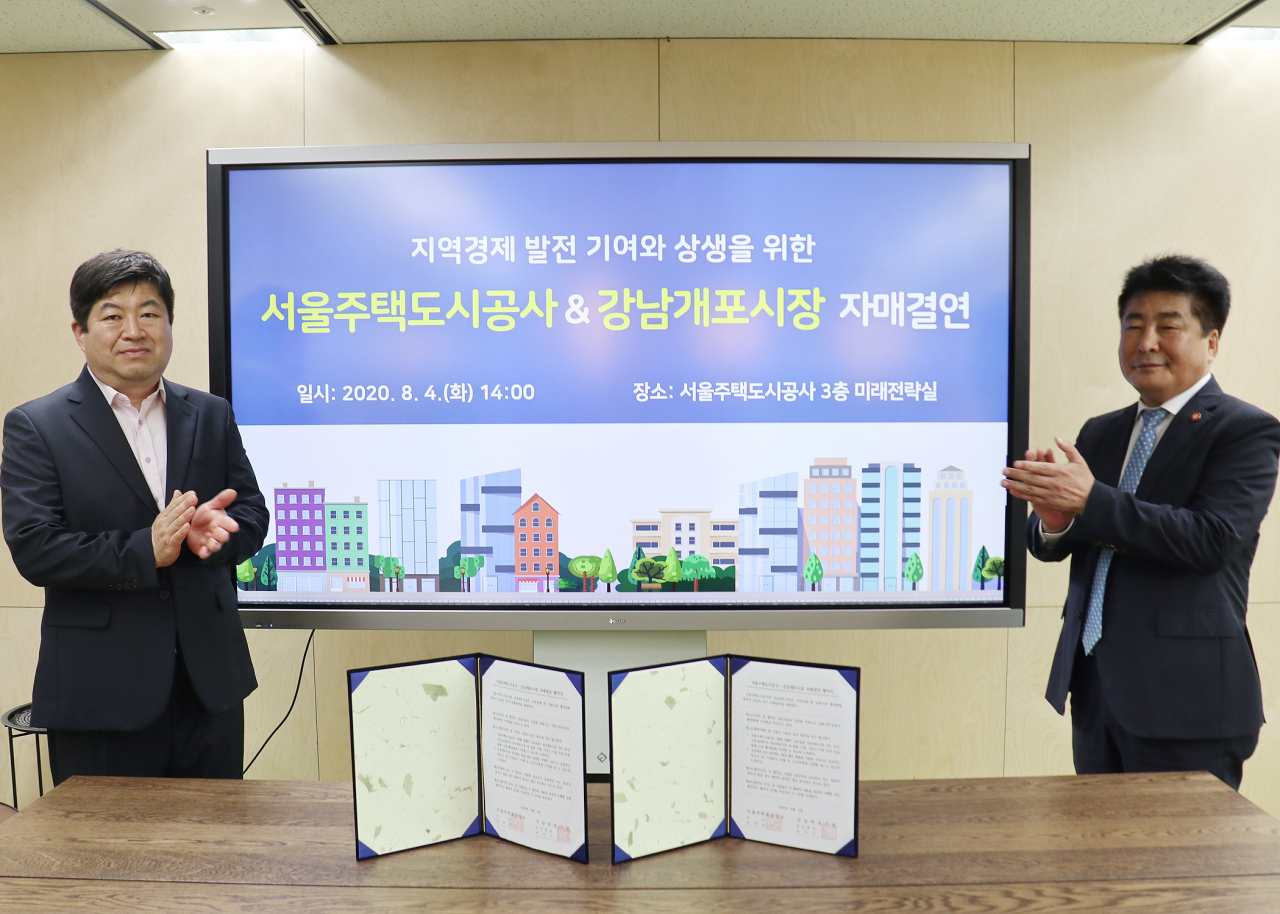 유상오 SH공사 미래전략실장(사진 왼쪽)과 윤선근 강남개포시장 상인회장이 지난 4일 서울 강남구 개포동 SH사옥에서 자매결연식을 맺고 기념촬영을 하고 있다.