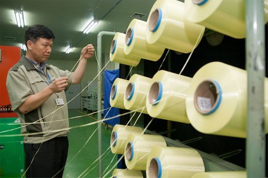 A Kolon Industries official checks the quality of aramid fibers at its plant in Gumi, North Gyeongsang Province.　(Kolon Industries)