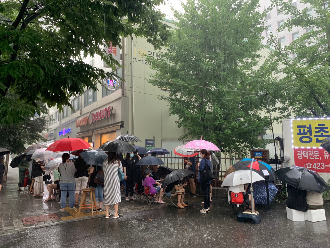 지난 5일 4시께 경기도 안양시 던킨도너츠 평촌점에서 캠핑용품 굿즈 폴딩박스를 구매하기 위해 빗속에서 사람들이 줄 서 있다. [사진=김빛나 기자]