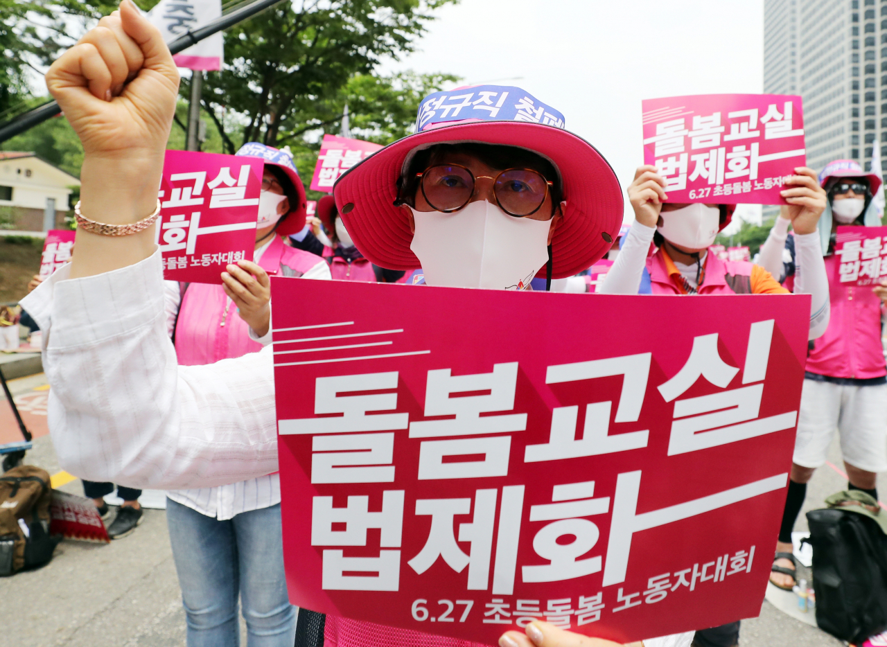 지난 달 27일 서울 여의도에서 전국학교비정규직노동조합 소속 돌봄교사 등이 돌봄교실 법제화, 돌봄 전담사 시간제 폐지 등을 주장하며 결의대회를 열고 구호를 외치고 있다. [연합]