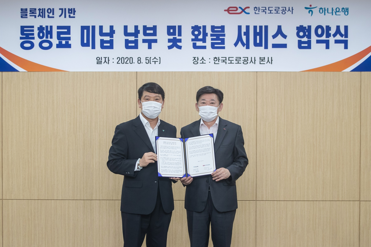 지난 5일 경북 김천에 소재한 한국도로공사 본사 4층 이사회의실에서 하나은행과 한국도로공사가 블록체인 기술 기반 서비스 도입을 위한 업무 협약을 체결했다. 염정호 하나은행 미래금융그룹장(왼쪽)과 이광호 한국도로공사 영업본부장이 기념 촬영을 하고 있다. [자료=하나은행]