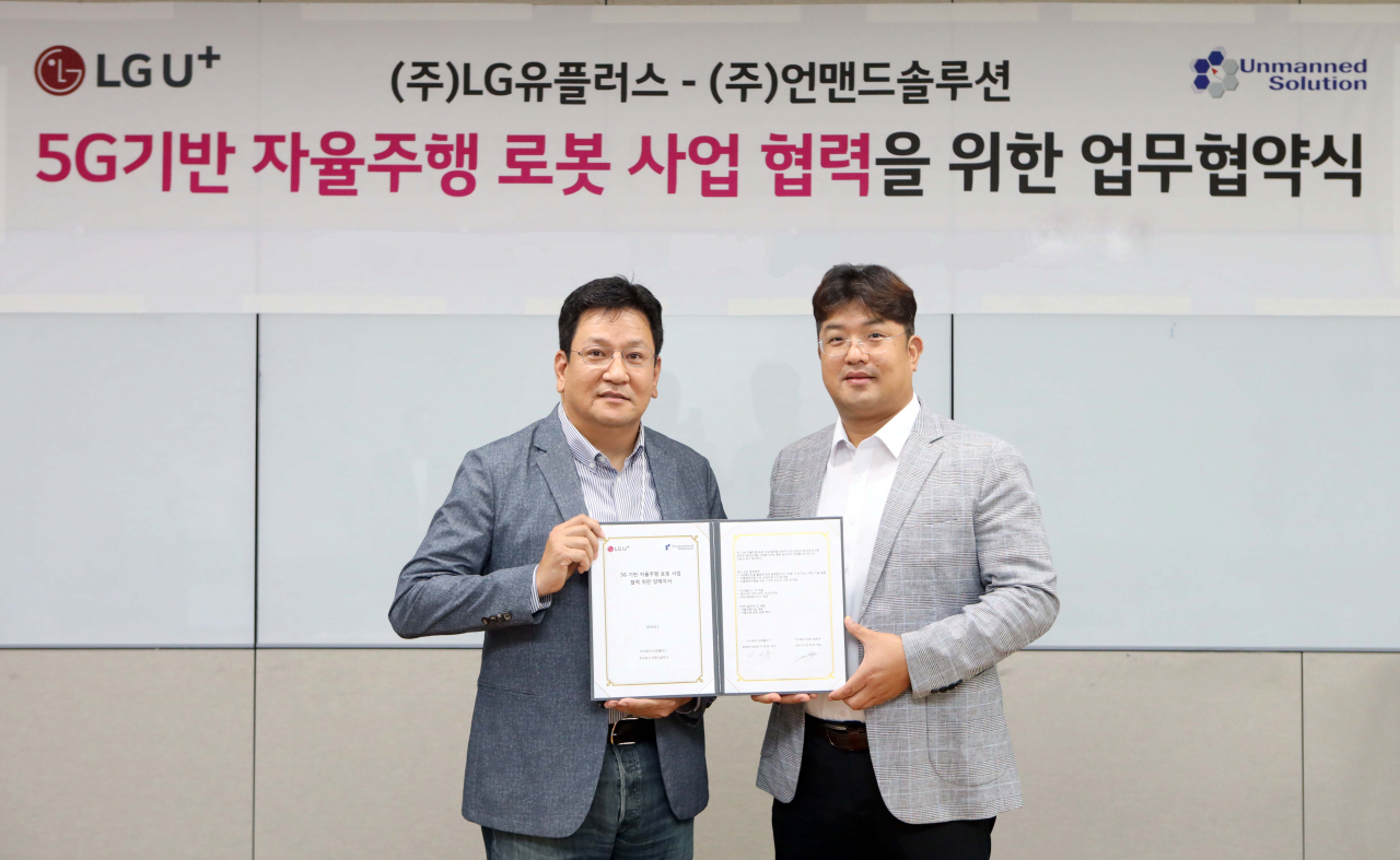 LG유플러스는 자율주행 로봇 전문업체 언맨드솔루션과 ‘자율주행 로봇사업’에 관한 업무협약(MOU)을 체결했다고 6일 밝혔다. 사진은 LG유플러스 용산사옥에서 진행된 업무협약 체결식에서 서재용 LG유플러스 융복합사업담당 상무(왼쪽)와 문희창 언맨드솔루션 대표(오른쪽)가 기념 촬영하고 있는 모습. [LG유플러스 제공]