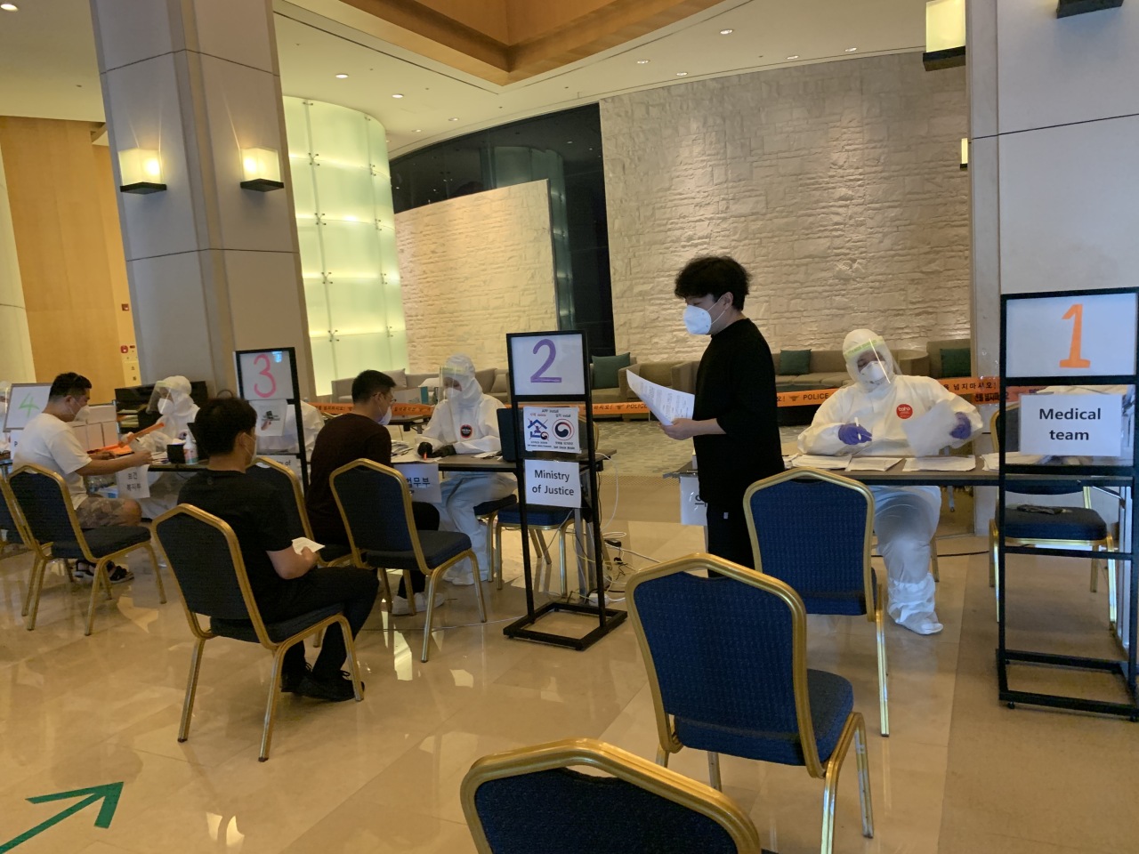 After having their samples collected for testing, passengers are required to fill out a medical questionnaire and install a government-developed health app to monitor their symptoms. Instructions are provided in seven languages.