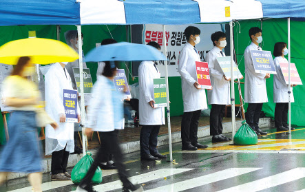 의대 정원 확대 정부 정책에 반발해 전공의들이 파업에 나선 7일 오전 광주 조선대학교병원 앞에서 의대생들이 전공의 파업에 동조하기 위해 구호가 적힌 피켓을 들고 서 있다. [연합]