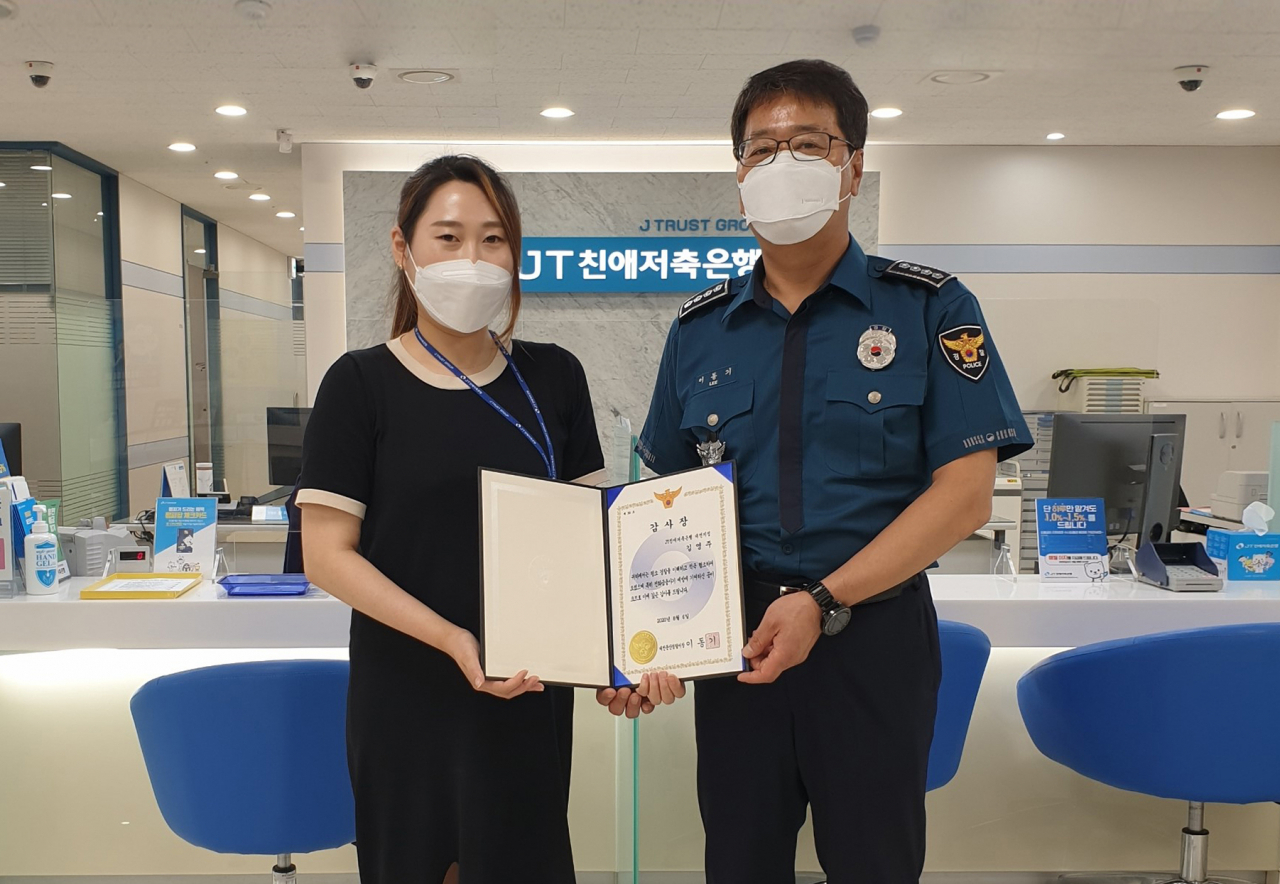 6일 대전지점 김영주 계장이 억대 보이스피싱을 예방한 공로로 이동기 대전둔산경찰서장에게 감사장을 받고있다. [JT친애저축은행 제공]