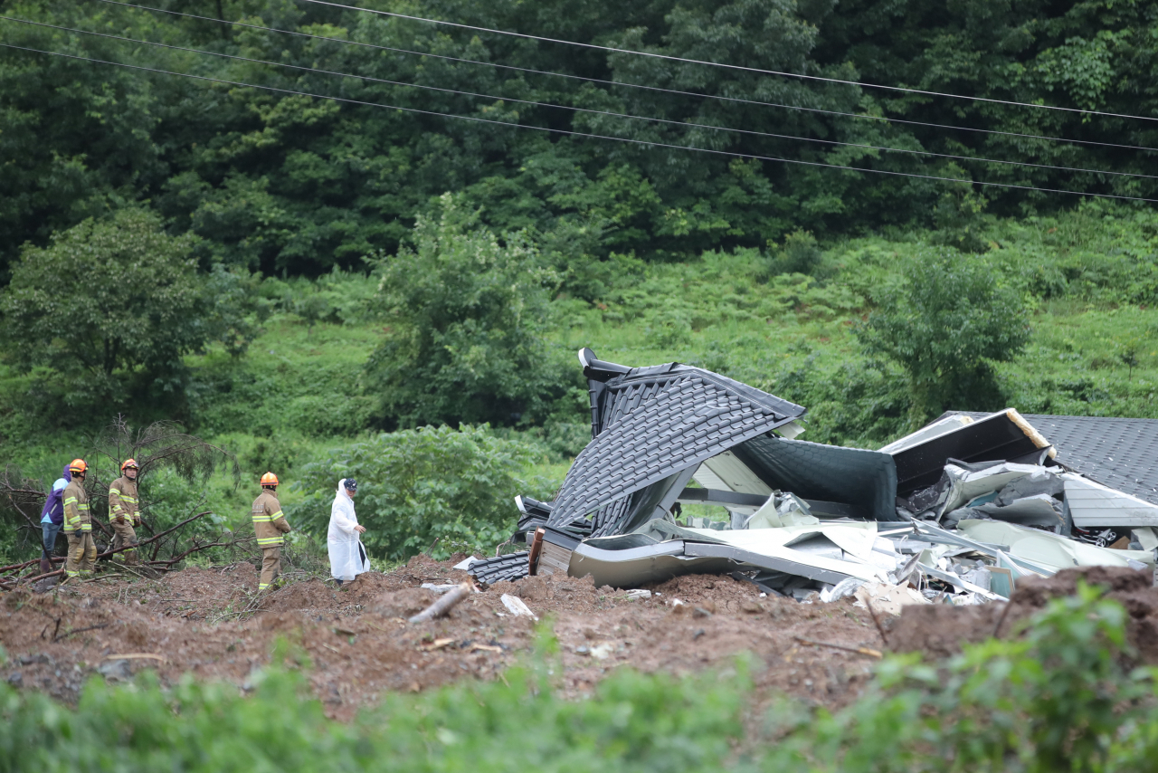 8일 오전 전남 곡성군 오산면 산사태가 발생한 주택에서 구조대가 매몰자를 수색하고 있다. 전날 오후 8시 29분께 발생한 산사태로 이곳 주택 3동에서 5명이 매몰됐다. [연합]