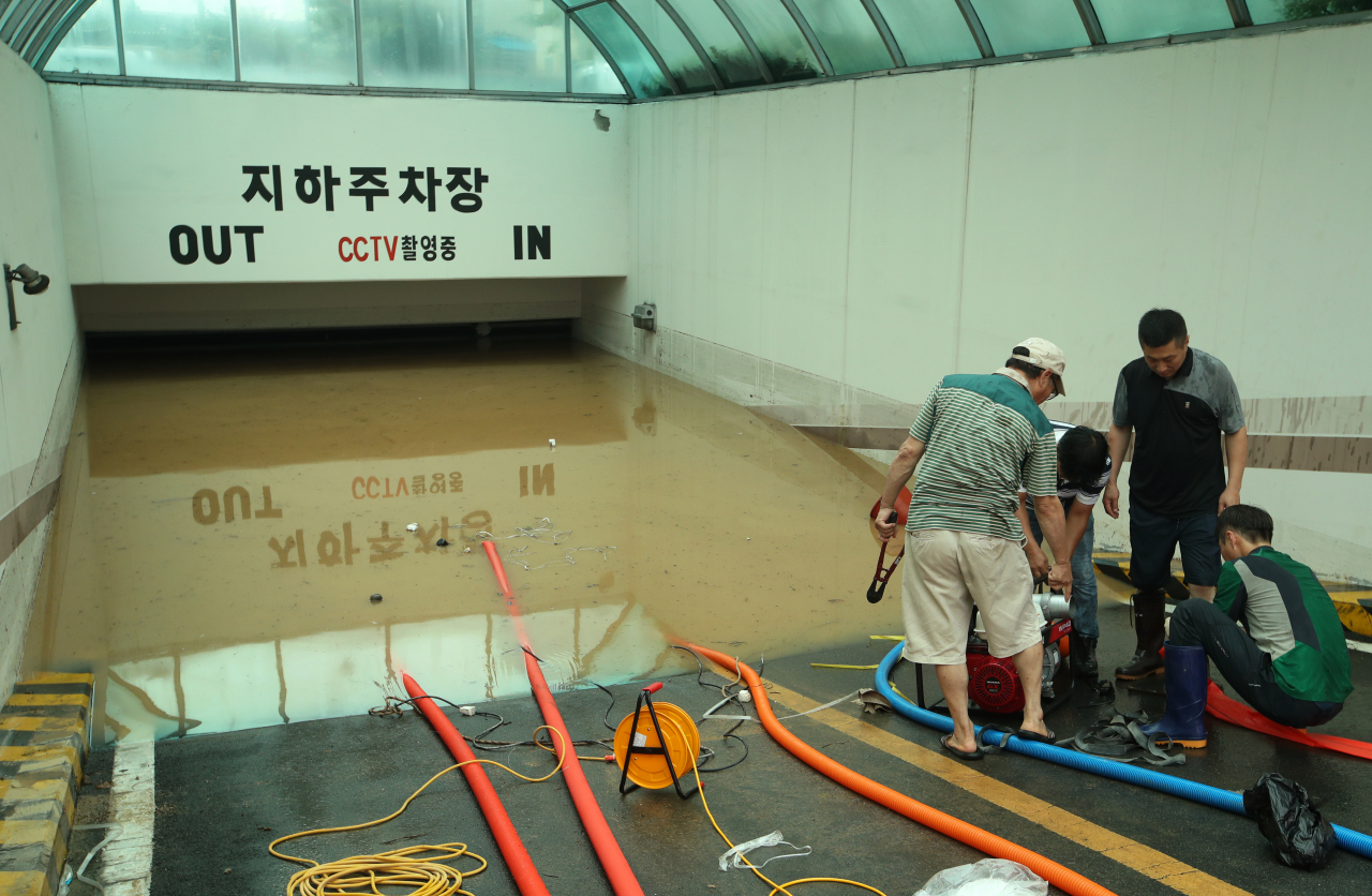 집중호우가 내린 8일 광주 북구 신안교의 범람 여파로 침수된 신안동의 한 아파트 지하주차장에서 배수작업이 이뤄지고 있다. 연합뉴스