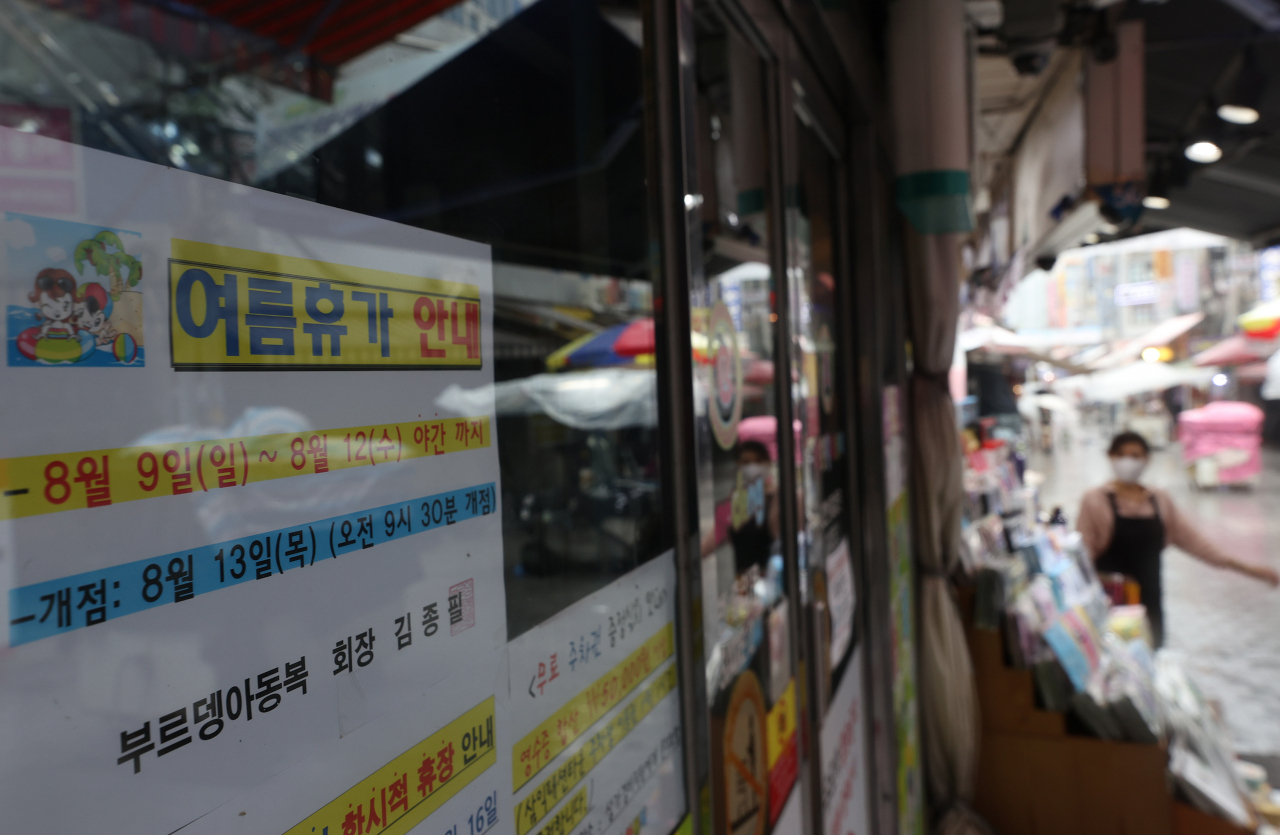 휴가철인 9일 오전 서울 중구 남대문시장 아동복 상가 입구에 여름 휴가를 알리는 안내문이 붙어 있다. 연합뉴스