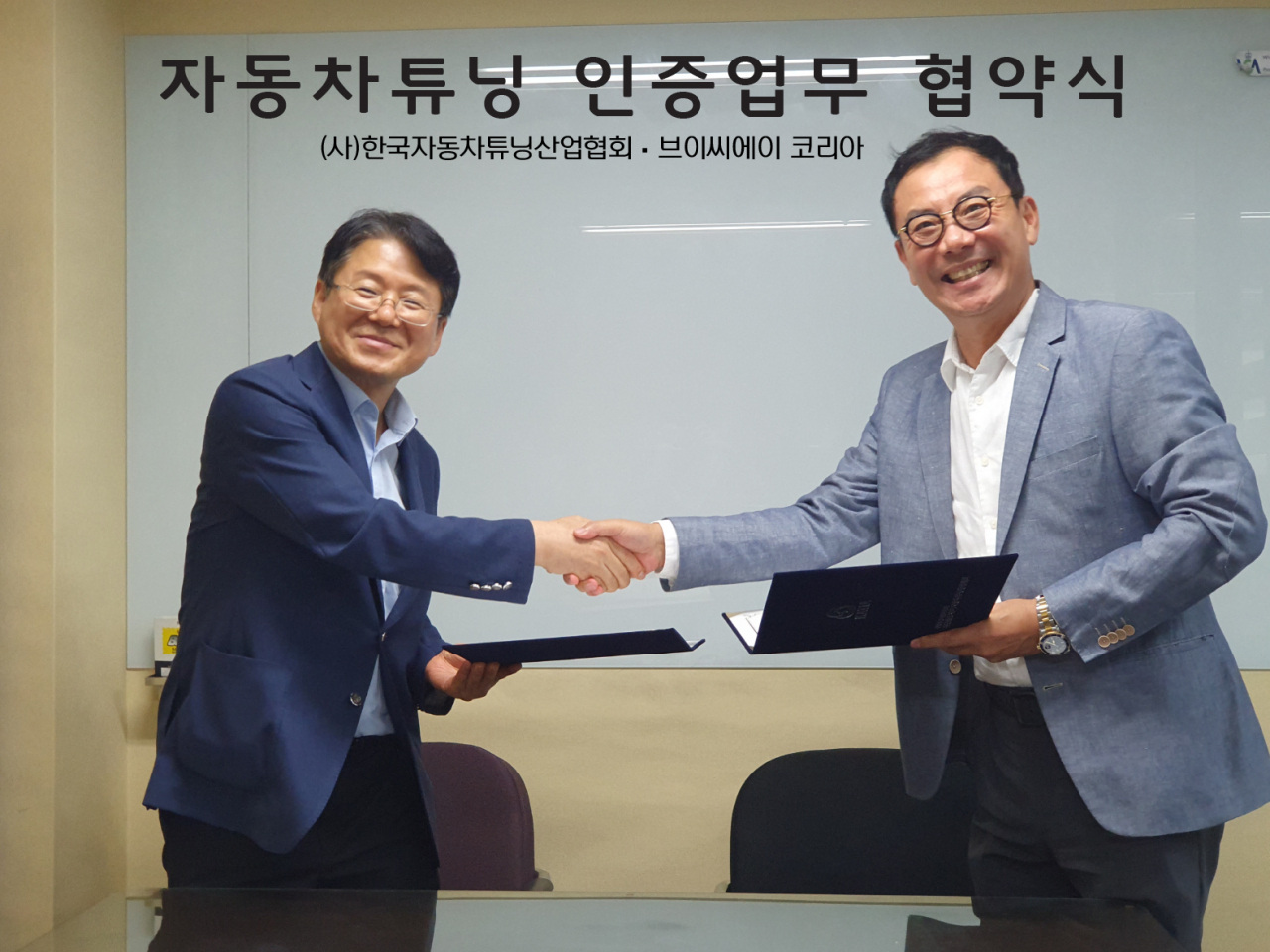 김필수(왼쪽) 한국자동차튜닝산업협회 회장과 이명구 VCA 코리아 지사장이 업무 협약을 체결하고 악수하고 있다. [한국자동차튜닝산업협회 제공]