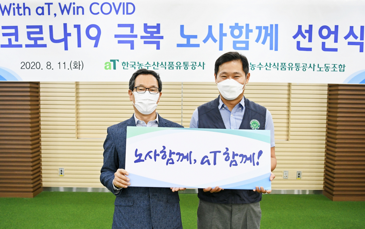 이병호(왼쪽) 사장과 서권재 노동조합 위원장이 노사 대표로 선언문을 낭독한 뒤 기념촬영을 하고 있다. [aT 제공]