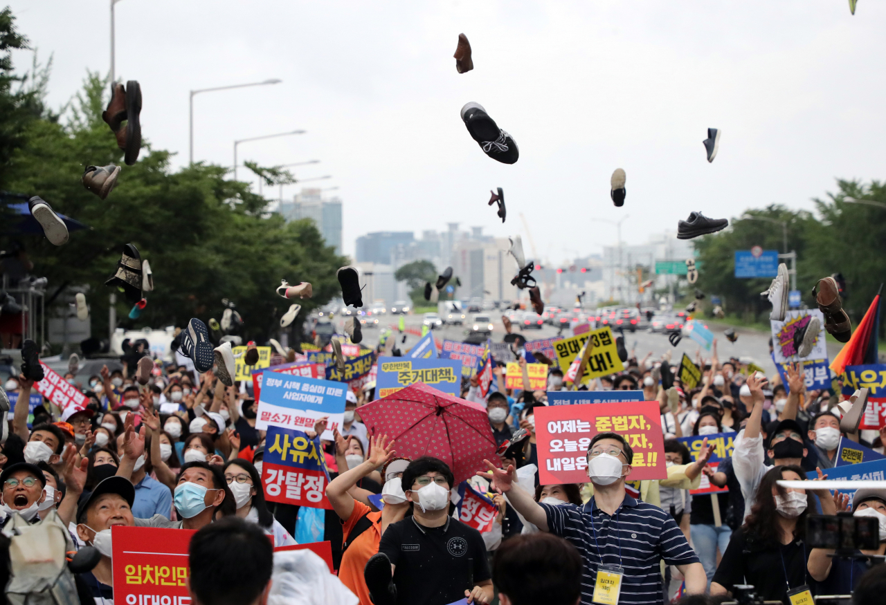 지난 1일 서울 영등포구 여의도광장에서 6·17규제 소급적용 피해자모임, 임대사업자협회 추인위원회 등 부동산 관련 단체 회원들이 정부의 부동산 규제에 반대하는 집회를 열고 신발투척 퍼포먼스를 하고 있다. [연합]