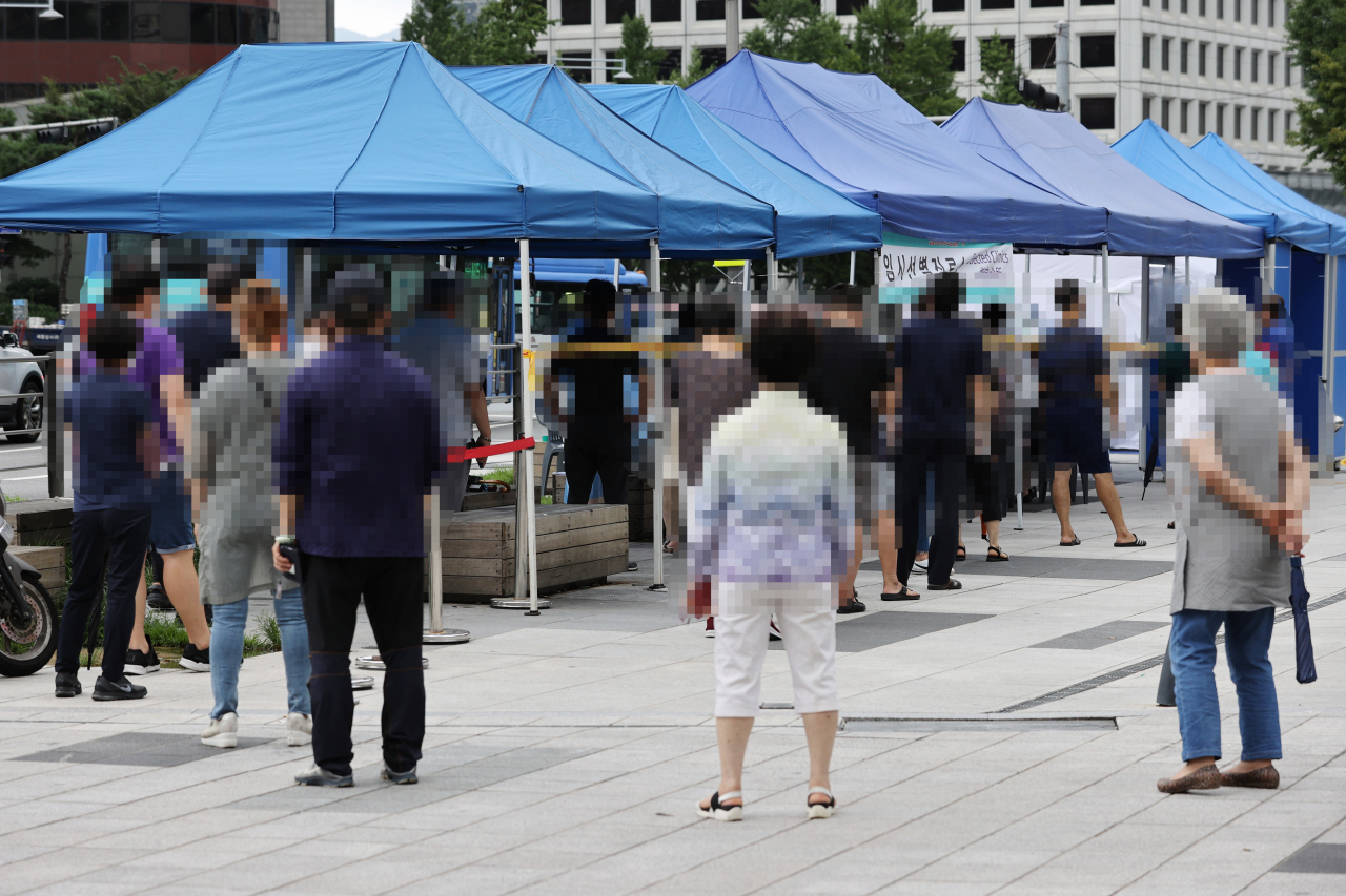 지난 11일 오후 서울 중구 남대문시장에 마련된 임시선별진료소에서 시민들이 검사를 받기 위해 줄을 서고 있다. [연합]
