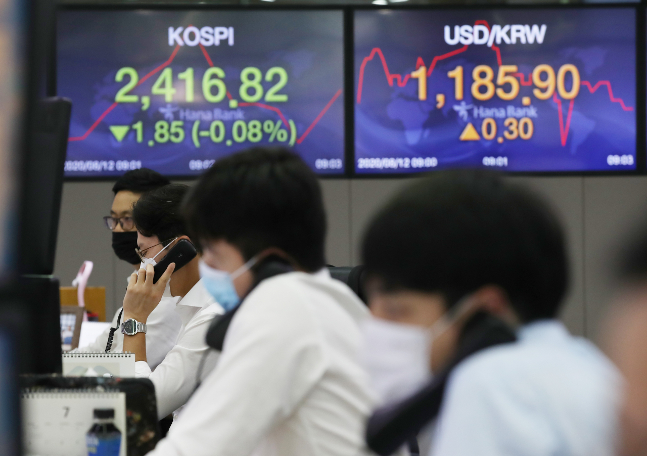 코스피가 약보합세로 출발한 12일 오전 서울 중구 하나은행 본점 딜링룸에서 직원이 업무를 보고 있다. [연합]