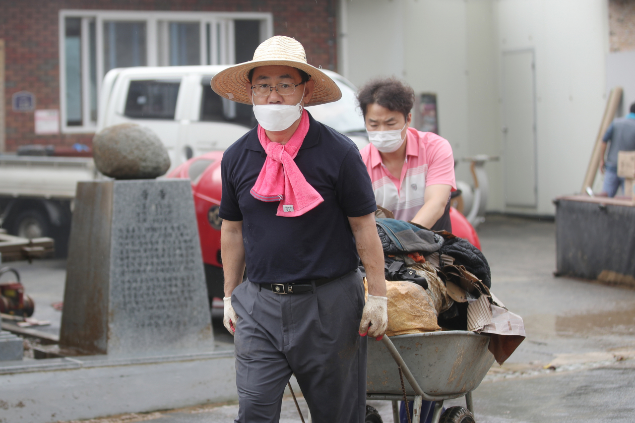 11일 오전 전남 구례군 문척면 구성마을에서 미래통합당 주호영 원내대표가 마을회관에 남아있는 침수 피해 폐기물을 옮기고 있다. [연합]