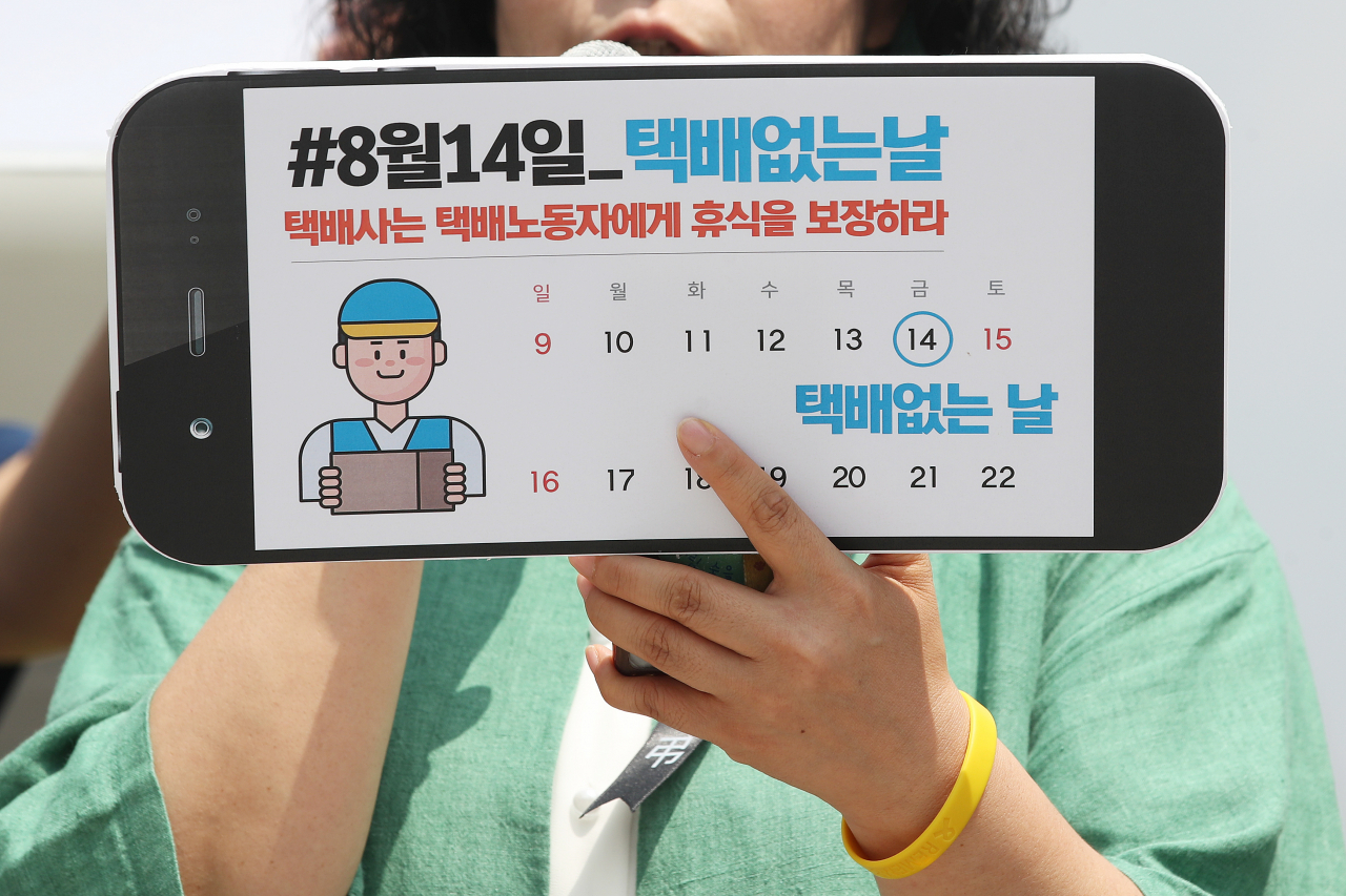 지난달 9일 오전 서울 광화문광장에서 열린 '8월 14일을 택배없는 날로 지정하라!'기자회견에서 참석자가 택배 없는 날 지정을 촉구하는 손팻말을 들고 있다. [연합]
