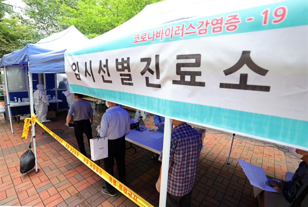14일 서울 중구 통일시장 앞에 마련된 신종 코로나바이러스감염증(코로나19) 임시선별진료소에서 상인과 시민들이 검사를 위해 대기하고 있다. [연합]