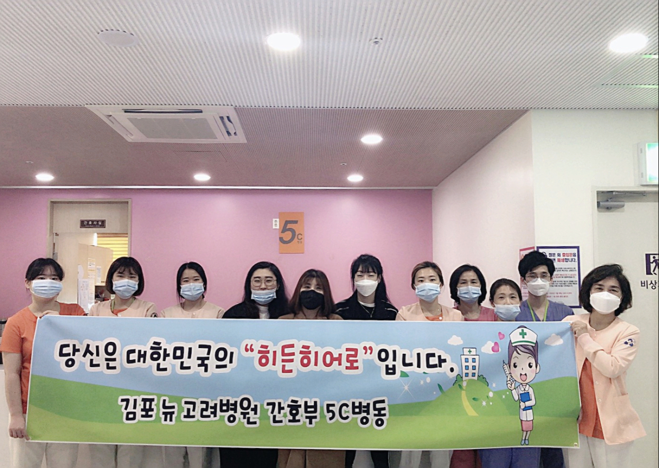 Head nurse Jo Hyo-jung (fifth from left) at a hospital in Gimpo gets a send off from colleagues as she leaves duty to work at a COVID-19 facility with a sign which reads “You are Korea’s hidden hero.” (courtesy of Jo)