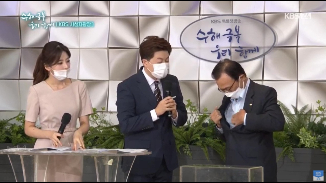 이해찬 더불어민주당 대표(오른쪽)가 14일 서울 여의도 KBS에서 열린 KBS 1TV '특별생방송 수해 극복 우리 함께'에서 '수해 성금봉투'를 찾기 위해 양복 상의 주머니를 이리저리 살펴보고 있다. 민주당 관계자는 "안주머니 안에 수첩 등 다양한 물건이 있어서 봉투를 바로 찾지 못했다"며 "퇴장한 뒤 봉투를 찾아 성금함에 넣었다"고 설명했다. [연합]
