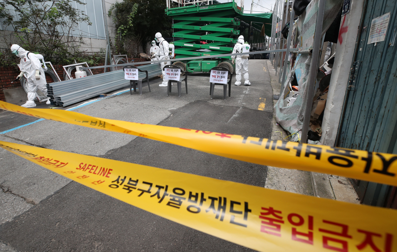 14일 오후 신종 코로나바이러스 감염증(코로나19) 집단발병이 발생한 서울 성북구 사랑제일교회 입구에서 관계자들이 방역 작업을 하고 있다. 서울시는 이날 성북구 사랑제일교회에 대해 시설 폐쇄 조치를 내렸다. [연합]