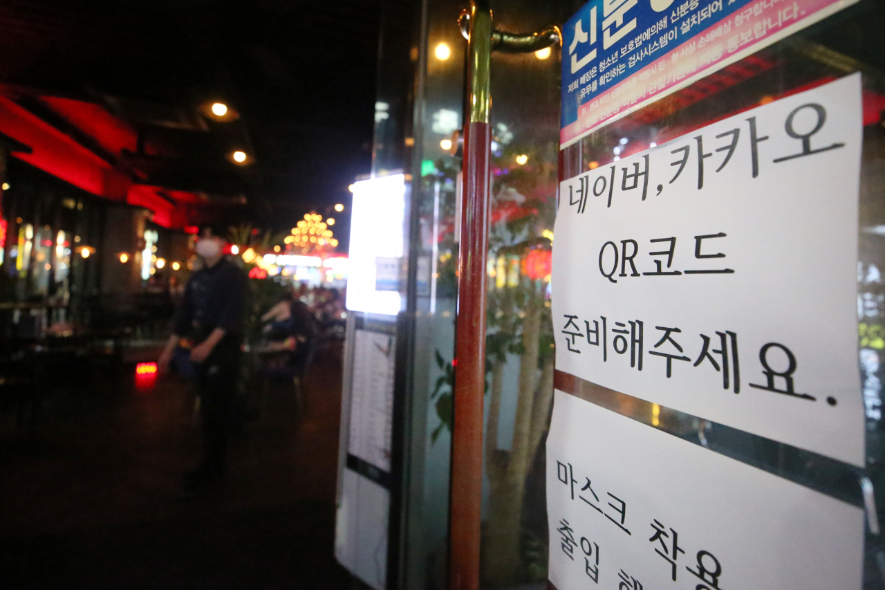 서구 상무지구 한 주점 앞에 전자출입명부 기록을 위해 QR코드를 제시해 달라는 안내문이 붙어 있다. 광주시는 지난달 27일부터 코로나19 확진자가 급증하자 사회적 거리두기를 2단계로 격상했다. [연합]