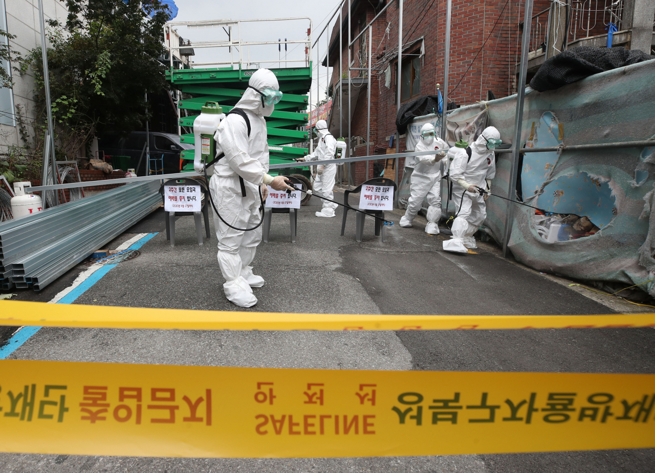 14일 오후 신종 코로나바이러스 감염증(코로나19) 집단발병이 발생한 서울 성북구 사랑제일교회 입구에서 관계자들이 방역 작업을 하고 있다. 서울시는 이날 성북구 사랑제일교회에 대해 시설 폐쇄 조치를 내렸다. 연합뉴스