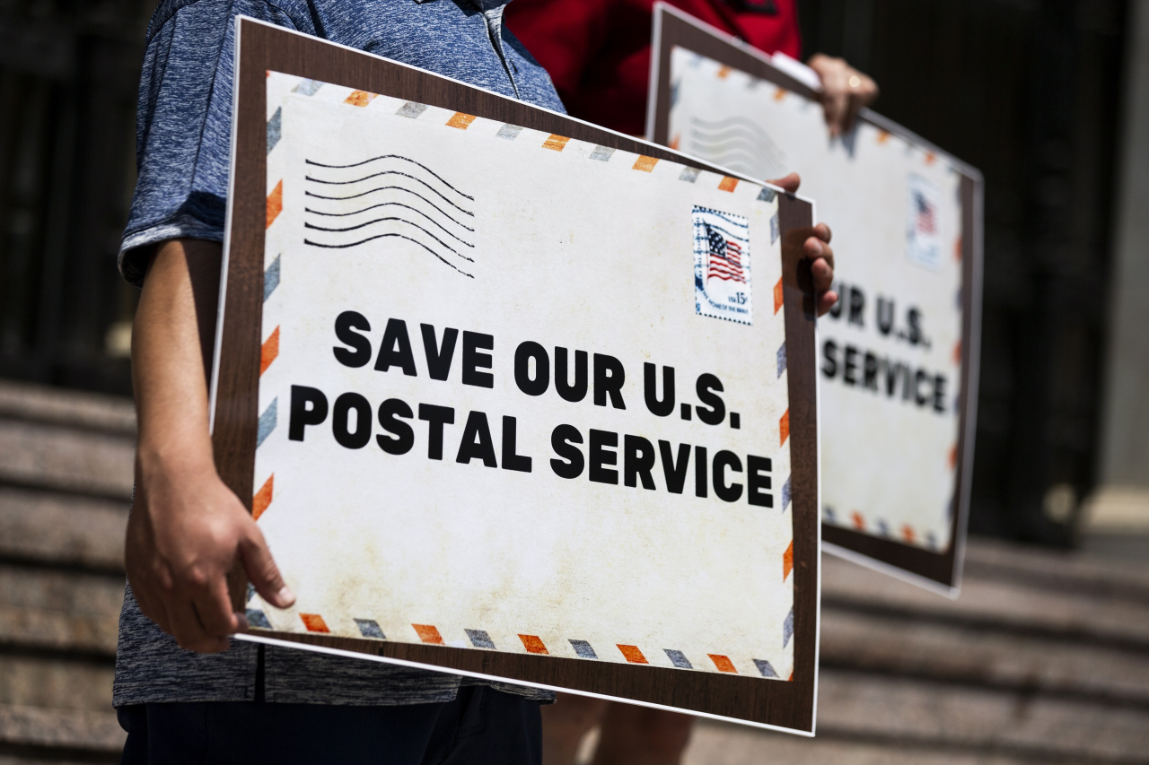 미국 연방우체국(USPS)는 18일(현지시간) 대선이 열리는 11월까지 우편투표에 영향을 줄 것이란 우려를 낳고 있는 비용절감 조치를 보류하기로 했다. 사진은 캘리포니아주 패서디나의 우체국 앞에서 시민들이 USPS의 비용절감 조치에 반대하는 시위를 벌이는 모습. [EPA]