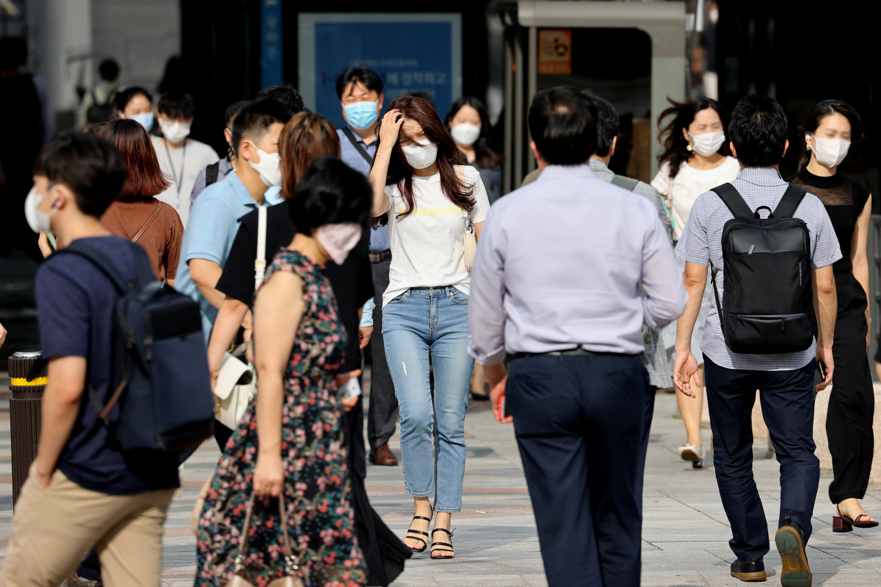 수도권을 중심으로 신종 코로나바이러스 감염증(코로나19) 확진자가 늘어나고 있는 가운데 19일 오전 서울 종로구 광화문 네거리에서 마스크를 쓴 시민들이 발걸음을 재촉하고 있다. [연합]