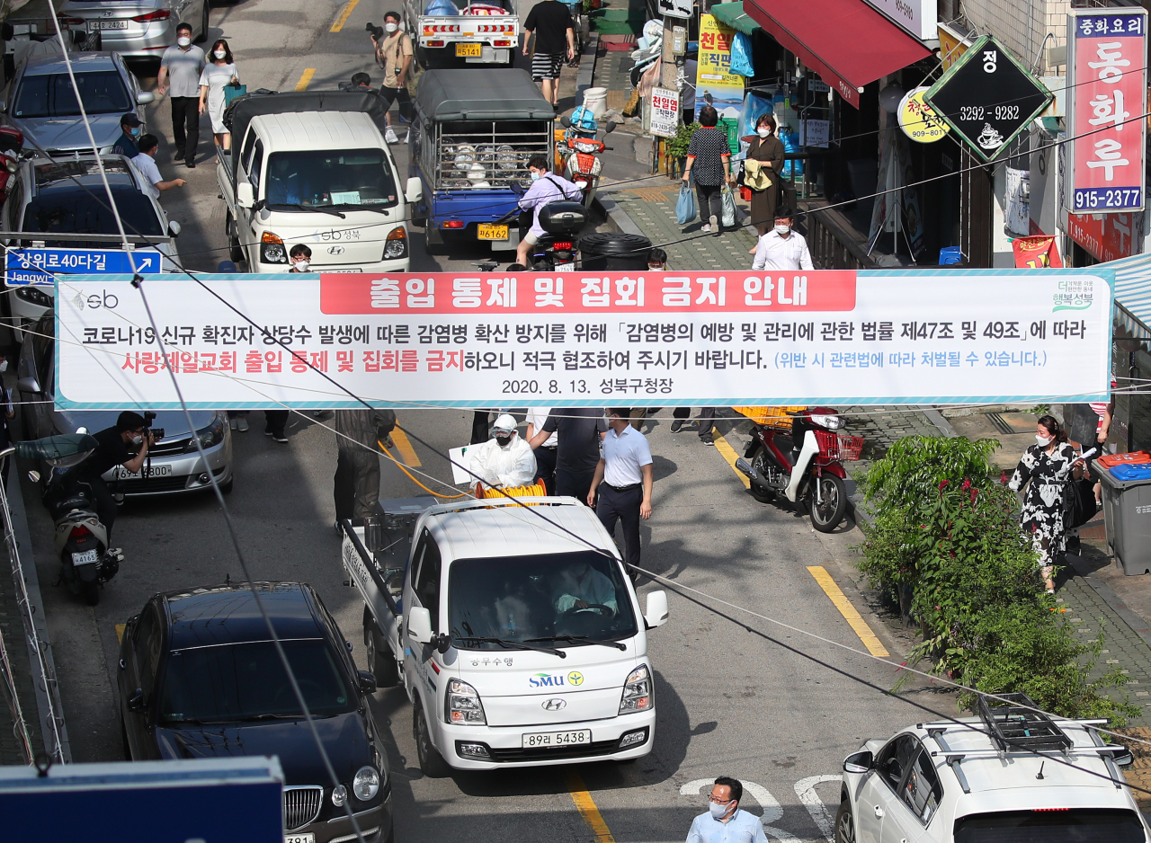 18일 오후 서울 성북구 장위2동 사랑제일교회 인근 도로에서 장위동 상인, 주민, 공무원 등이 합동 방역 활동을 벌이고 있다. [연합]