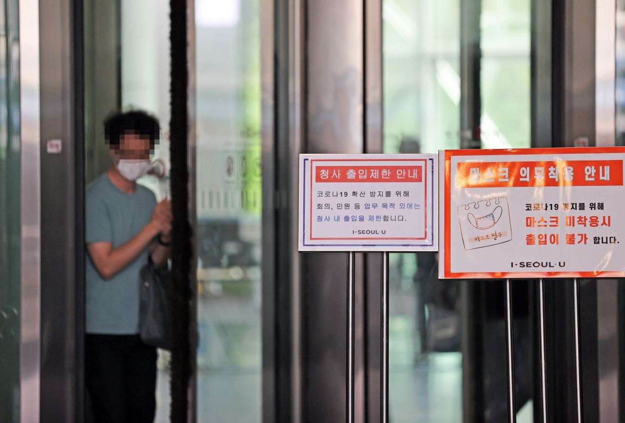 지난 19일 오후 서울시청 본관 2층에서 신종 코로나바이러스감염증(코로나19) 확진자가 발생해 직원들이 청사를 나서고 있다. [연합]