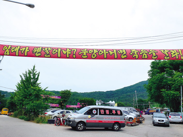구룡마을 입구에 붉은색 플래카드가 걸려있는 모습. [이민경 기자]