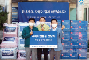자생의료재단 박병모 이사장(오른쪽)과 신민식 사회공헌위원장(왼쪽)이수해지원물품 전달식에서 한약과 침구류 기부 후 송악면 김영진 면장과 사진 촬영을 하고 있다. [자생의료재단 제공]